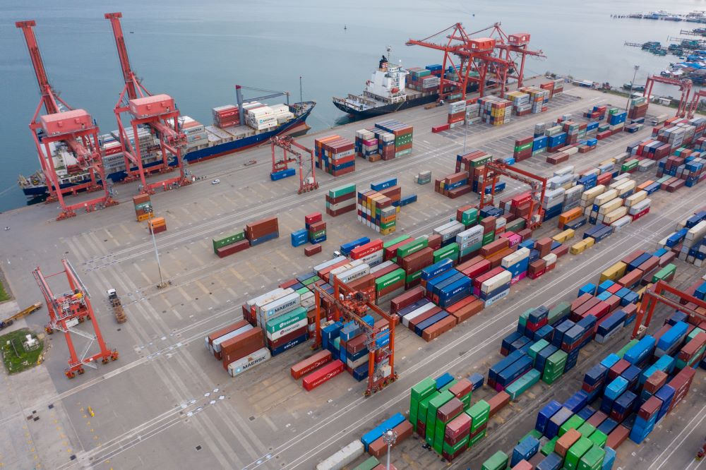 Port with ship and freight containers being transported