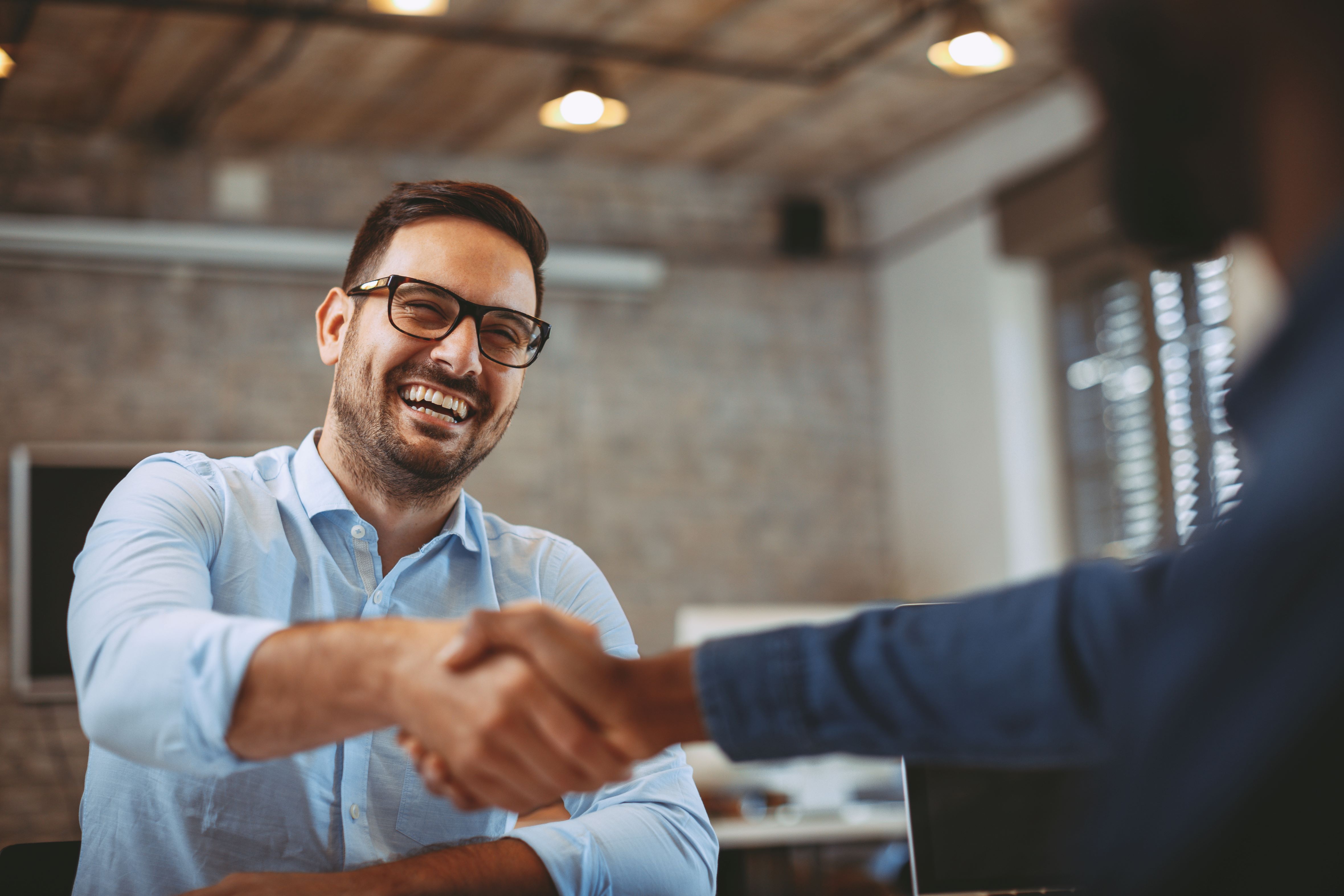 Businessman shaking mans with other person