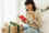 Woman reading Christmas card, surrounded by presents and Christmas decorations