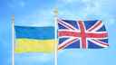 Ukraine and UK flags on flagpoles against a blue sky