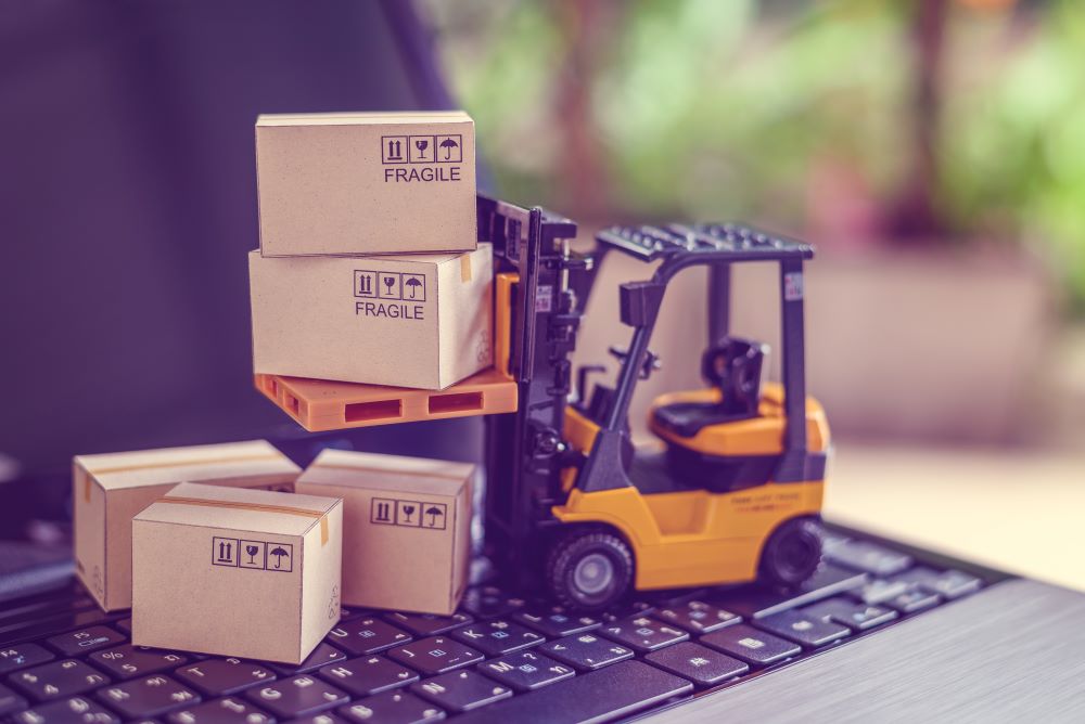 Toy forklift driving over laptop keys